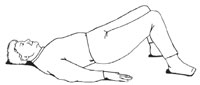 Side view of a man lying on his back with his arms by his sides, palm down. He is lifting his pelvis and buttocks off the ground. This strength training exercise is called a bridge.
