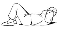 Side view of a man lying on his back with his hands behind his head, lifting his head off the ground. This is a strength training exercise called a crunch-up.