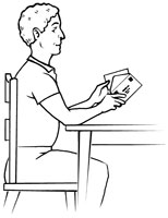 Man sitting in a chair to conserve energy while putting a letter into an envelope.